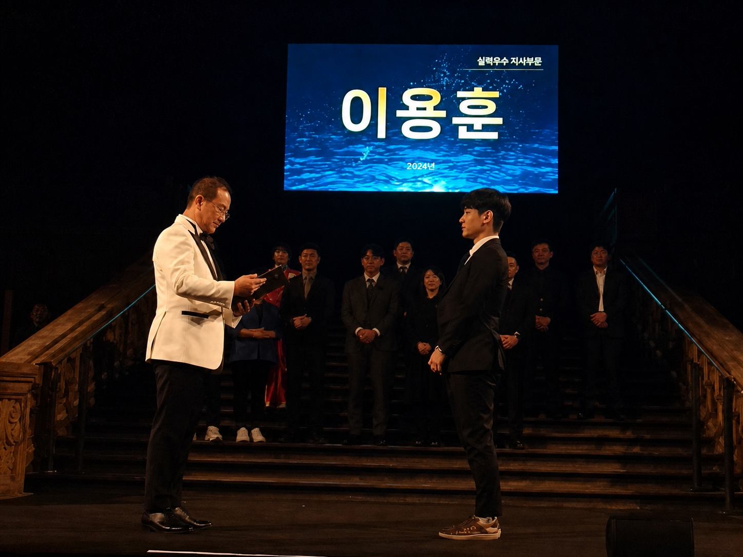 2024년 런던 CY23 실적우수 지사부문 시상 무대에 이용훈 이름이 표시된 모습